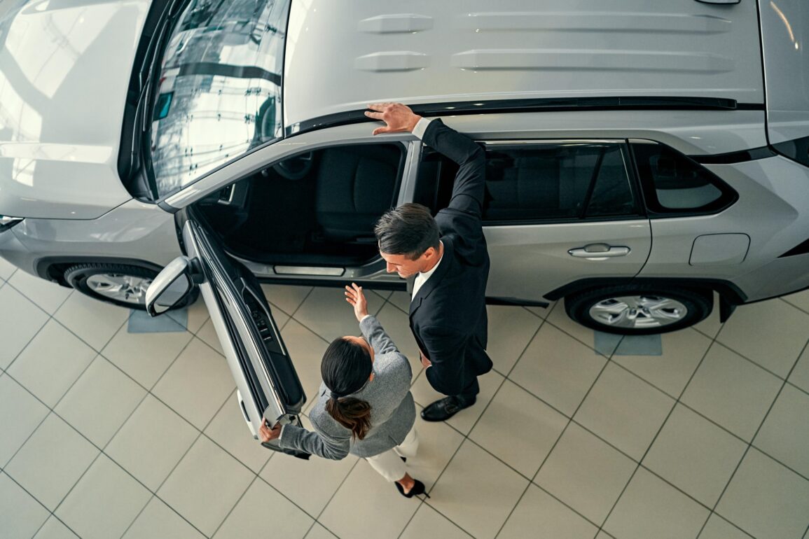 Customer with a grayscale vehicle on a showroom floor