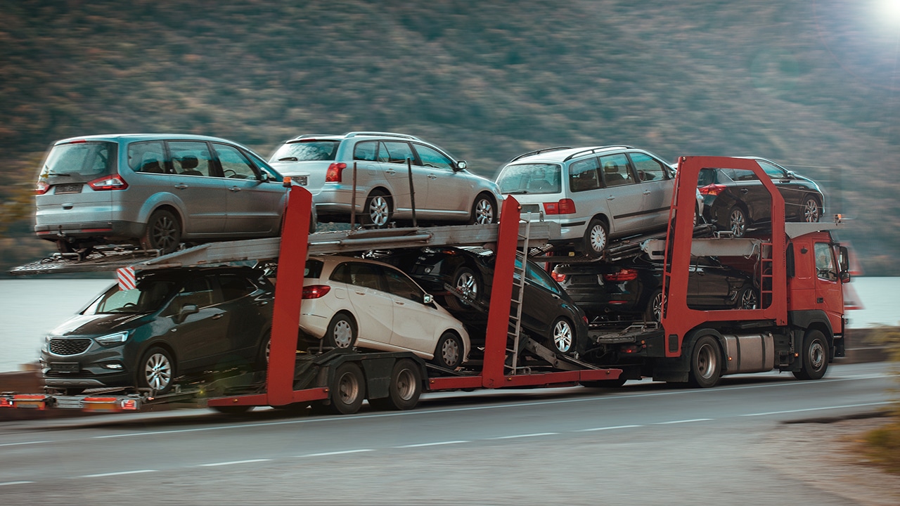 Easy Auto Ship reviews mention options like this open car carrier in motion down a highway with multiple cars on it.