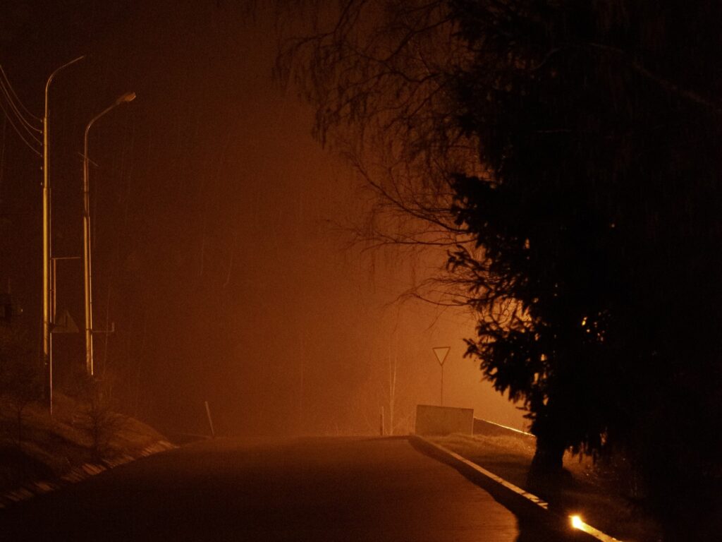 a haunted road glowing orange at night