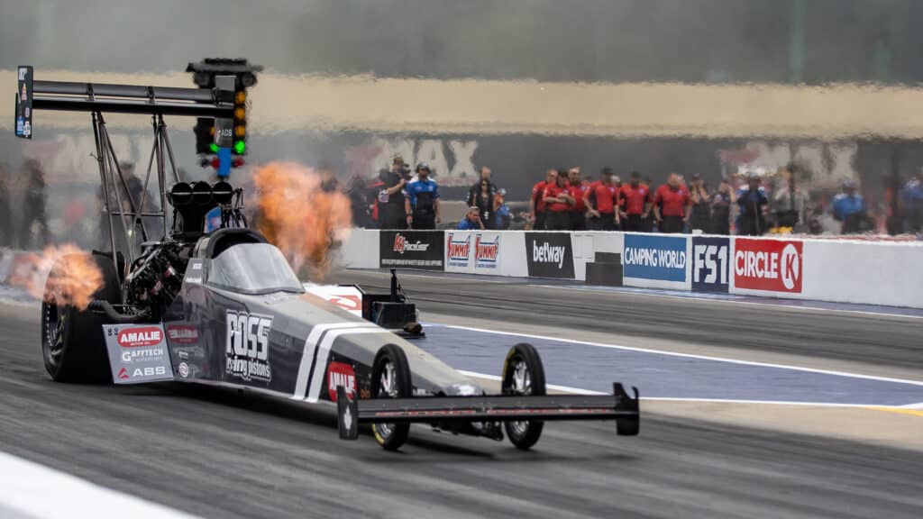 a top fuel dragster jumping off the start line with flames in the back of the vehicle