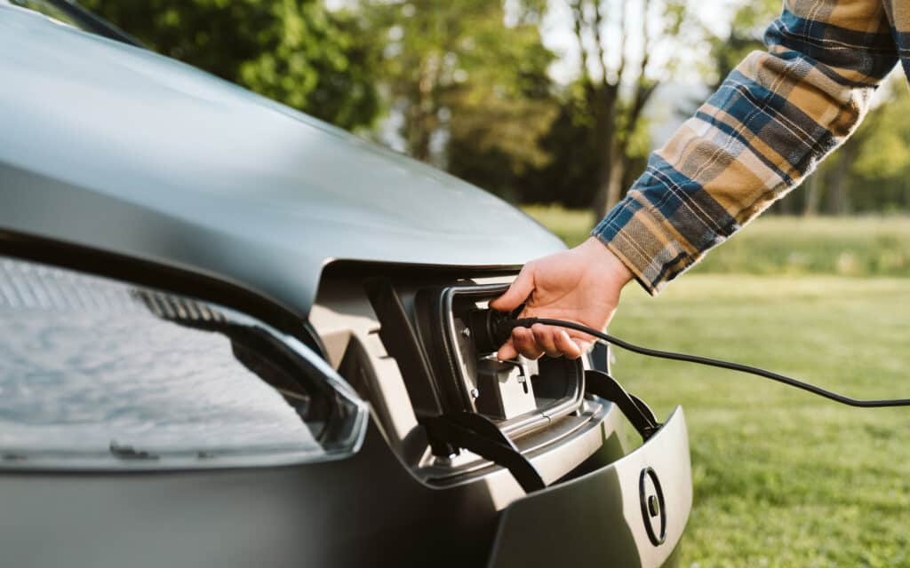 a hand plugs in a sono motors solar-powered ev