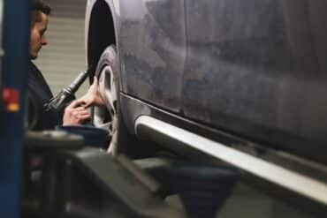 vehicles for change trains mechanics like this one changing a tire on a black car