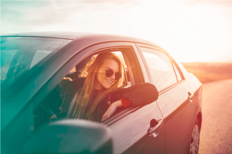 CARCHEX reviews say its warranties can give you peace of mind like this woman smiling while driving a car.